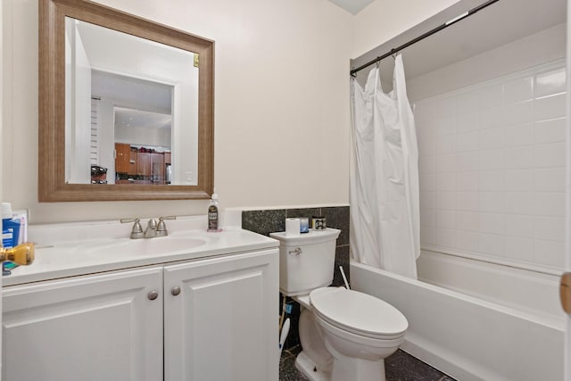bathroom featuring vanity, toilet, shower / bathtub combination with curtain, wainscoting, and tile walls