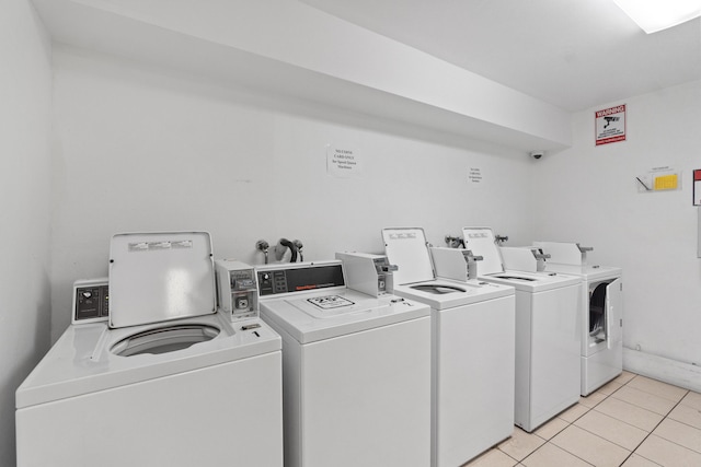 shared laundry area featuring separate washer and dryer and light tile patterned floors