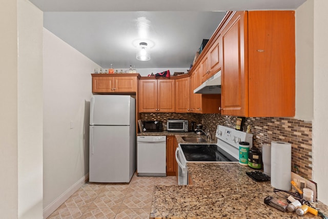 kitchen with a toaster, white appliances, under cabinet range hood, decorative backsplash, and a sink