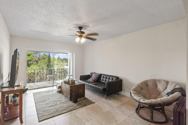 living room with a textured ceiling and ceiling fan