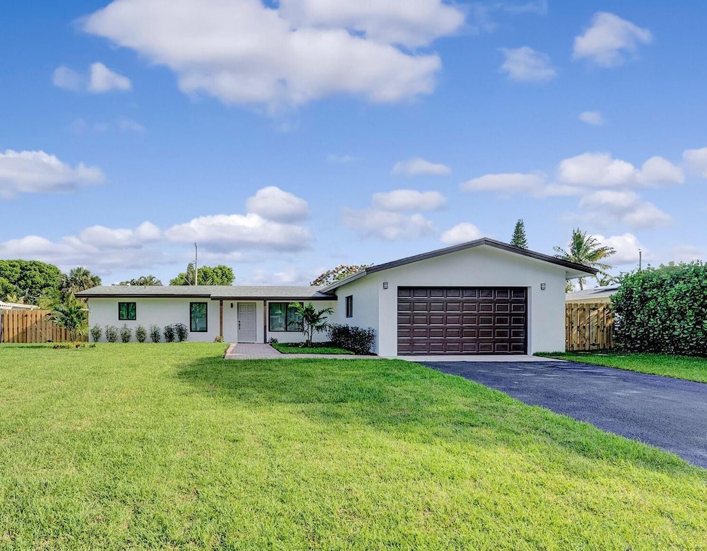460 NE 37th St NE, Boca Raton, FL 33431 - ranch-style home featuring a garage, aphalt driveway, stucco siding, and fence