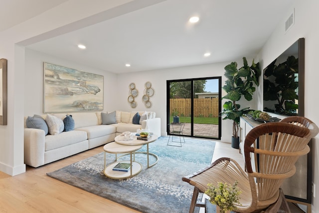 living area with recessed lighting, visible vents, and wood finished floors