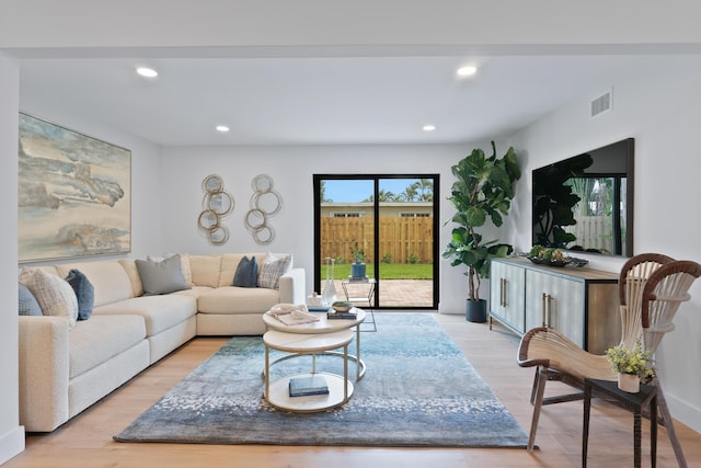 living room with visible vents, recessed lighting, and wood finished floors