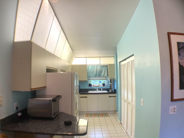 10501 SE Croft Ct Unit D-8, Hobe Sound, FL 33455 - kitchen with a sink, light tile patterned floors, and dark countertops