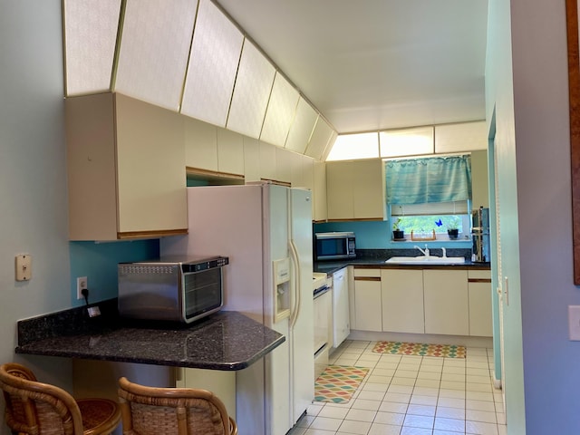 10501 SE Croft Ct Unit D-8, Hobe Sound, FL 33455 - kitchen with white refrigerator with ice dispenser, a sink, light tile patterned floors, a toaster, and stainless steel microwave