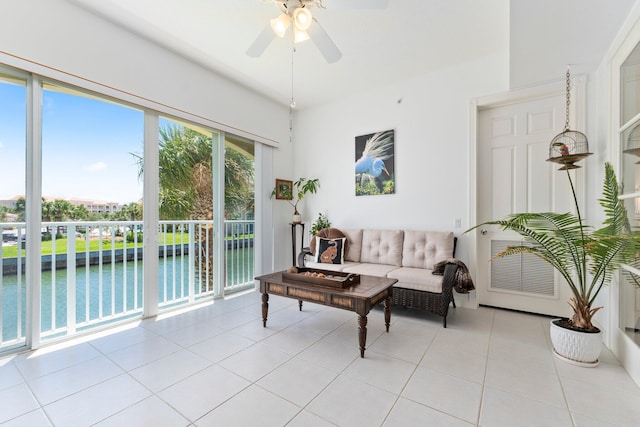 living room with a water view, ceiling fan, and light tile patterned flooring