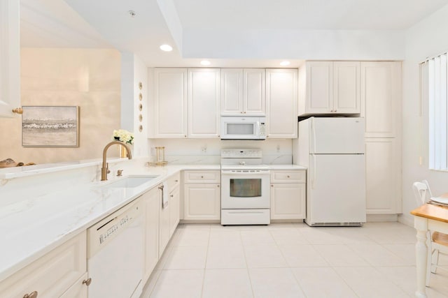 kitchen with a sink, light tile patterned flooring, recessed lighting, white appliances, and light stone counters