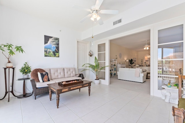 living room featuring light tile patterned floors, visible vents, and ceiling fan
