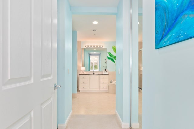 corridor featuring a sink, recessed lighting, and light tile patterned flooring
