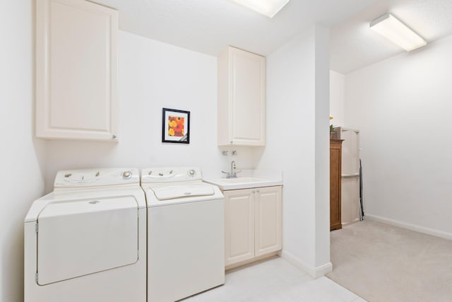 laundry room featuring washing machine and clothes dryer, a sink, cabinet space, light colored carpet, and baseboards