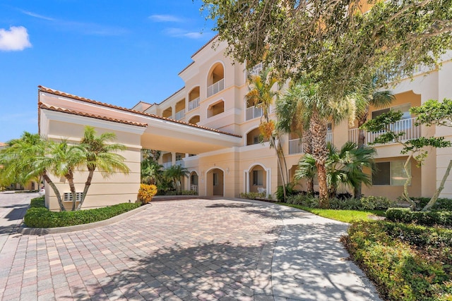 mediterranean / spanish house featuring stucco siding and decorative driveway