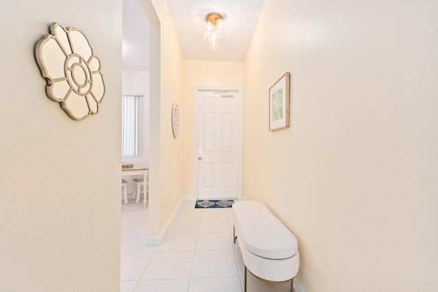 corridor featuring light tile patterned flooring and baseboards