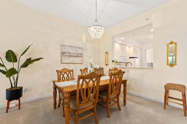 dining space featuring baseboards, a chandelier, and light colored carpet