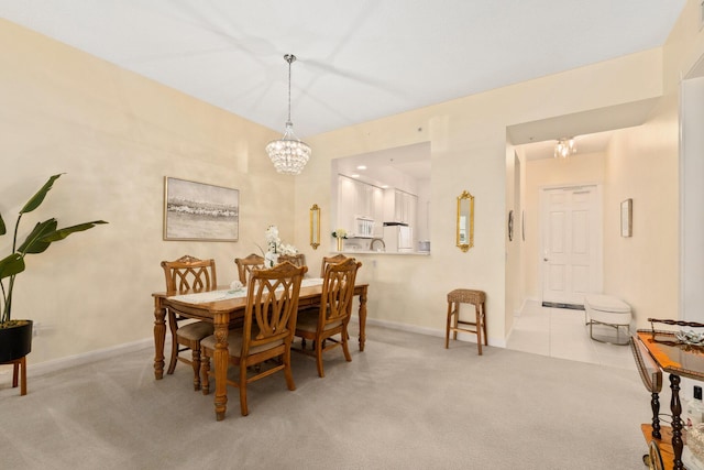 carpeted dining space featuring baseboards and a notable chandelier