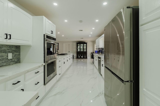 kitchen featuring stainless steel appliances, tasteful backsplash, marble finish floor, and recessed lighting