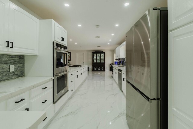 16250 SW 274th St, Homestead, FL 33031 - kitchen featuring stainless steel appliances, light marble finish flooring, tasteful backsplash, recessed lighting, and light stone counters
