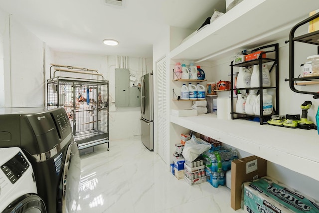 washroom with electric panel, washing machine and clothes dryer, marble finish floor, and laundry area