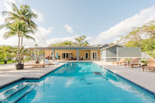 outdoor pool featuring a patio area and french doors