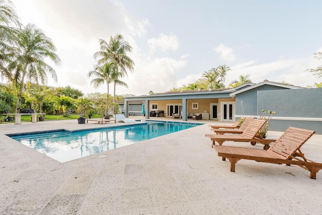 outdoor pool featuring a patio area and french doors