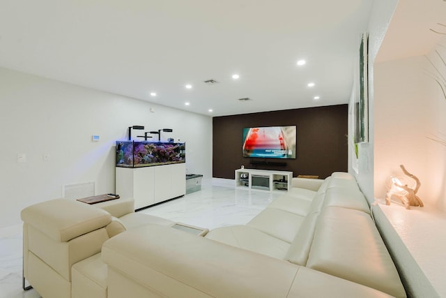 living area with visible vents, marble finish floor, an accent wall, and recessed lighting