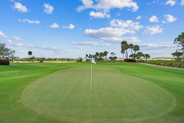 view of home's community featuring view of golf course and a putting green