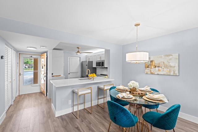 dining room featuring light wood-style flooring and baseboards