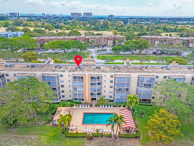 drone / aerial view of a pool area and apartment complex