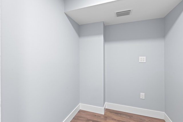 empty room featuring baseboards and dark wood-type flooring