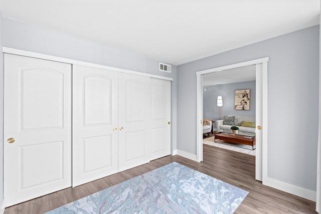 bedroom with baseboards, a closet, and wood finished floors