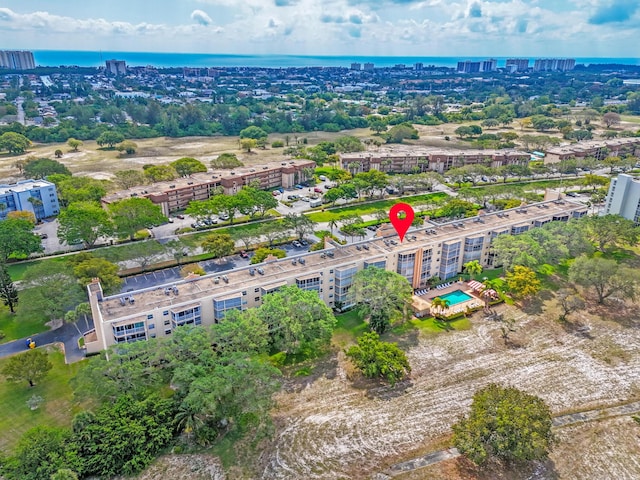 aerial view of property and surrounding area featuring apartment complex / building, a nearby body of water, and nearby urban area