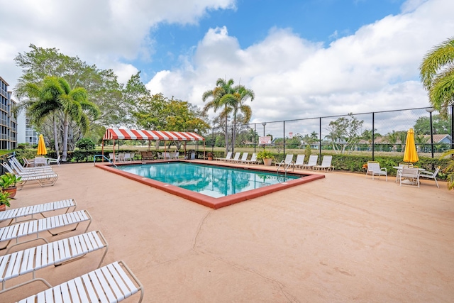 community pool featuring a patio and fence