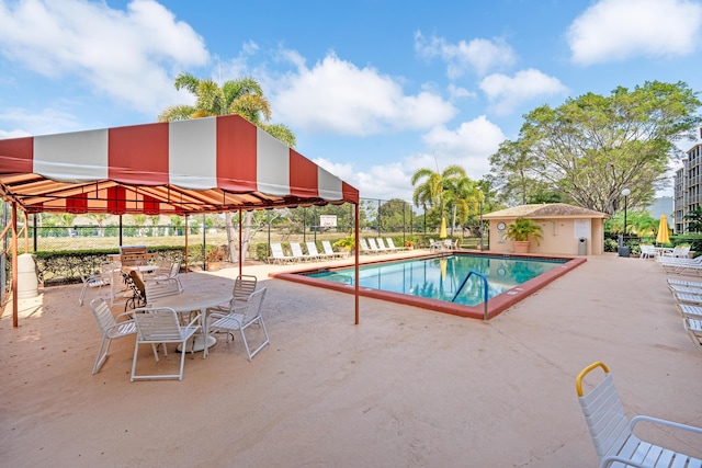 community pool with a patio and fence