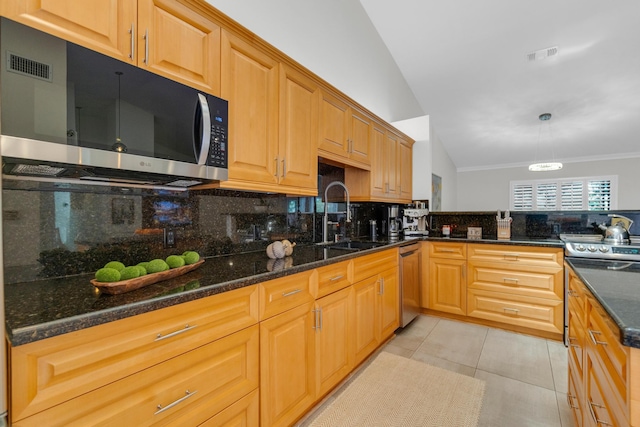 kitchen with stainless steel appliances, dark stone countertops, visible vents, a sink, and decorative backsplash