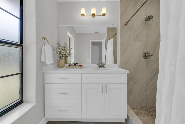 full bath featuring vanity and a tile shower