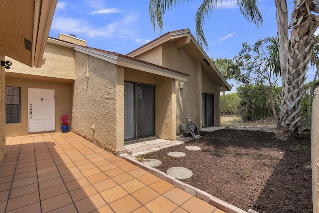 rear view of property with stucco siding and a patio