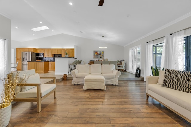 living room with light wood finished floors, lofted ceiling with skylight, recessed lighting, and crown molding