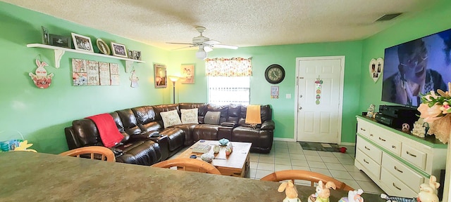 living room featuring tile patterned floors, a ceiling fan, visible vents, and a textured ceiling