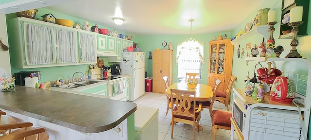 kitchen featuring light tile patterned floors, a sink, white appliances, a peninsula, and under cabinet range hood