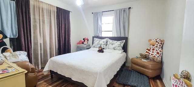 bedroom featuring wood finished floors and baseboards