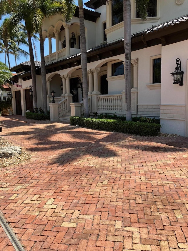 3131 NE 27th Ave, Lighthouse Point, FL 33064 - view of front of property featuring covered porch, a tiled roof, stucco siding, and a garage