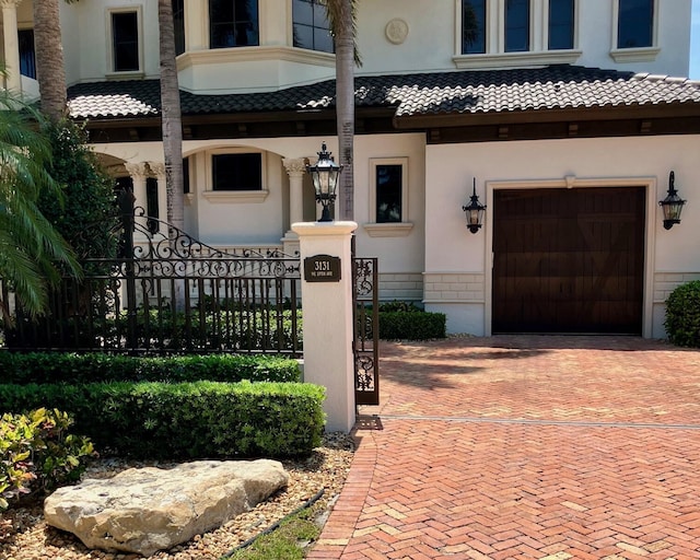 3131 NE 27th Ave, Lighthouse Point, FL 33064 - entrance to property featuring decorative driveway, a garage, a tiled roof, and stucco siding