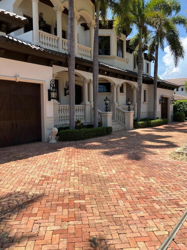 3131 NE 27th Ave, Lighthouse Point, FL 33064 - view of front of house with a balcony, stucco siding, and a garage