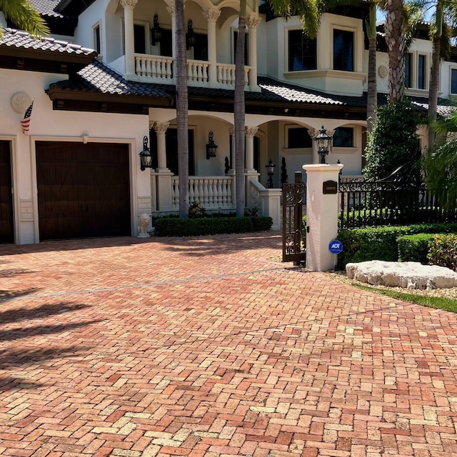 3131 NE 27th Ave, Lighthouse Point, FL 33064 - view of front of property featuring a porch, stucco siding, a fenced front yard, and a garage