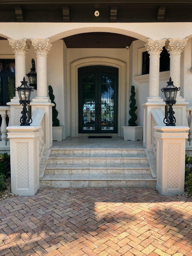 3131 NE 27th Ave, Lighthouse Point, FL 33064 - view of exterior entry with french doors, stucco siding, and covered porch