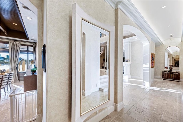 3131 NE 27th Ave, Lighthouse Point, FL 33064 - hallway featuring crown molding, arched walkways, recessed lighting, stone tile flooring, and baseboards