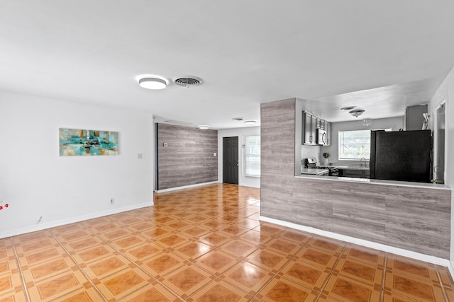 3700 N Australian Ave, West Palm Beach, FL 33407 - unfurnished living room featuring baseboards and a sink