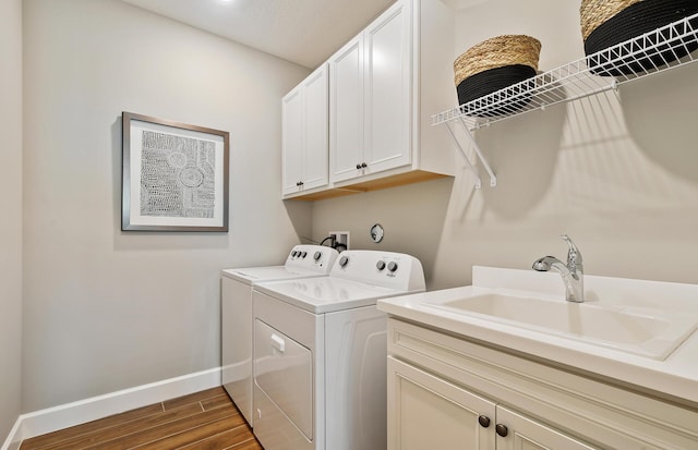 clothes washing area featuring cabinet space, separate washer and dryer, baseboards, and dark wood finished floors