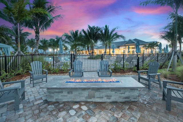 patio terrace at dusk featuring fence and a fire pit