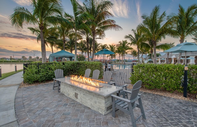 view of patio / terrace with a fire pit, a gazebo, and a water view