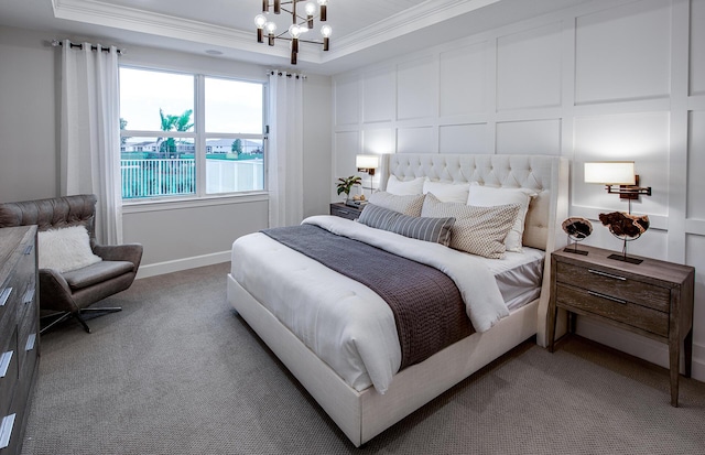 bedroom featuring ornamental molding, carpet flooring, a raised ceiling, a chandelier, and a decorative wall